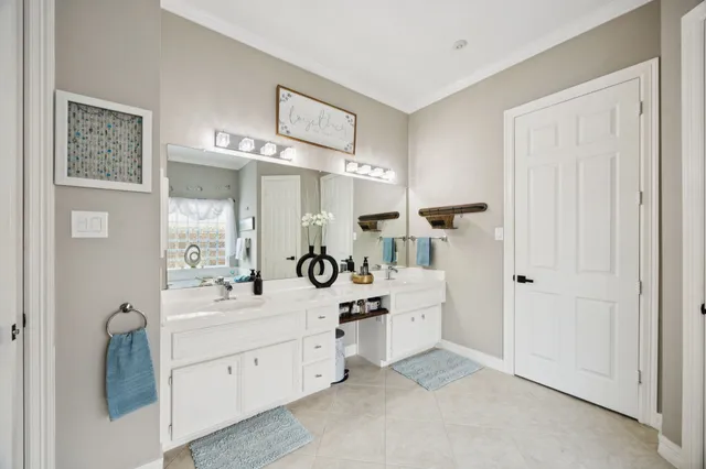 a spacious bathroom with a double vanity sink a mirror a bathtub and shower