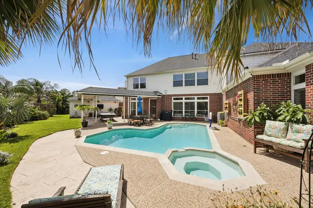 a view of a house with swimming pool and sitting area