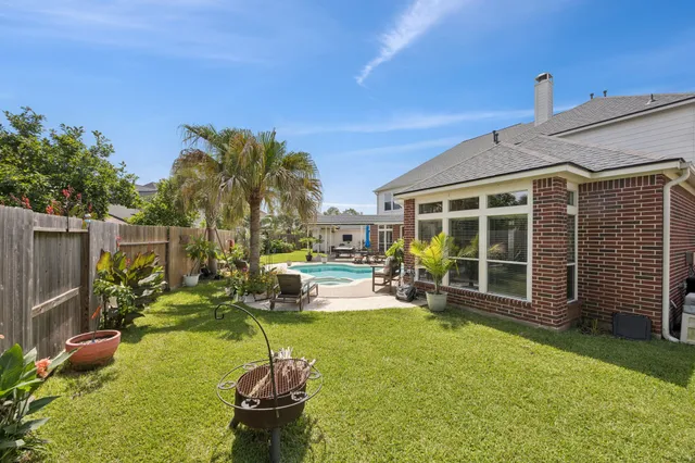 a swimming pool with outdoor seating and yard