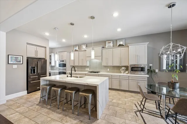 a kitchen with appliances cabinets and chair