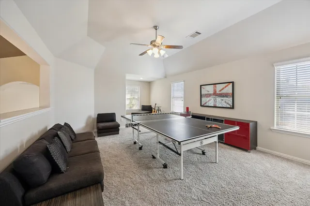 a living room with furniture a dining table and a chandelier
