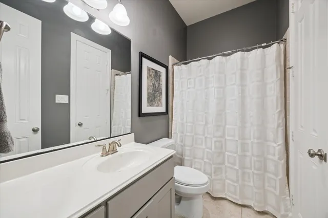 a bathroom with a sink a toilet and shower curtain