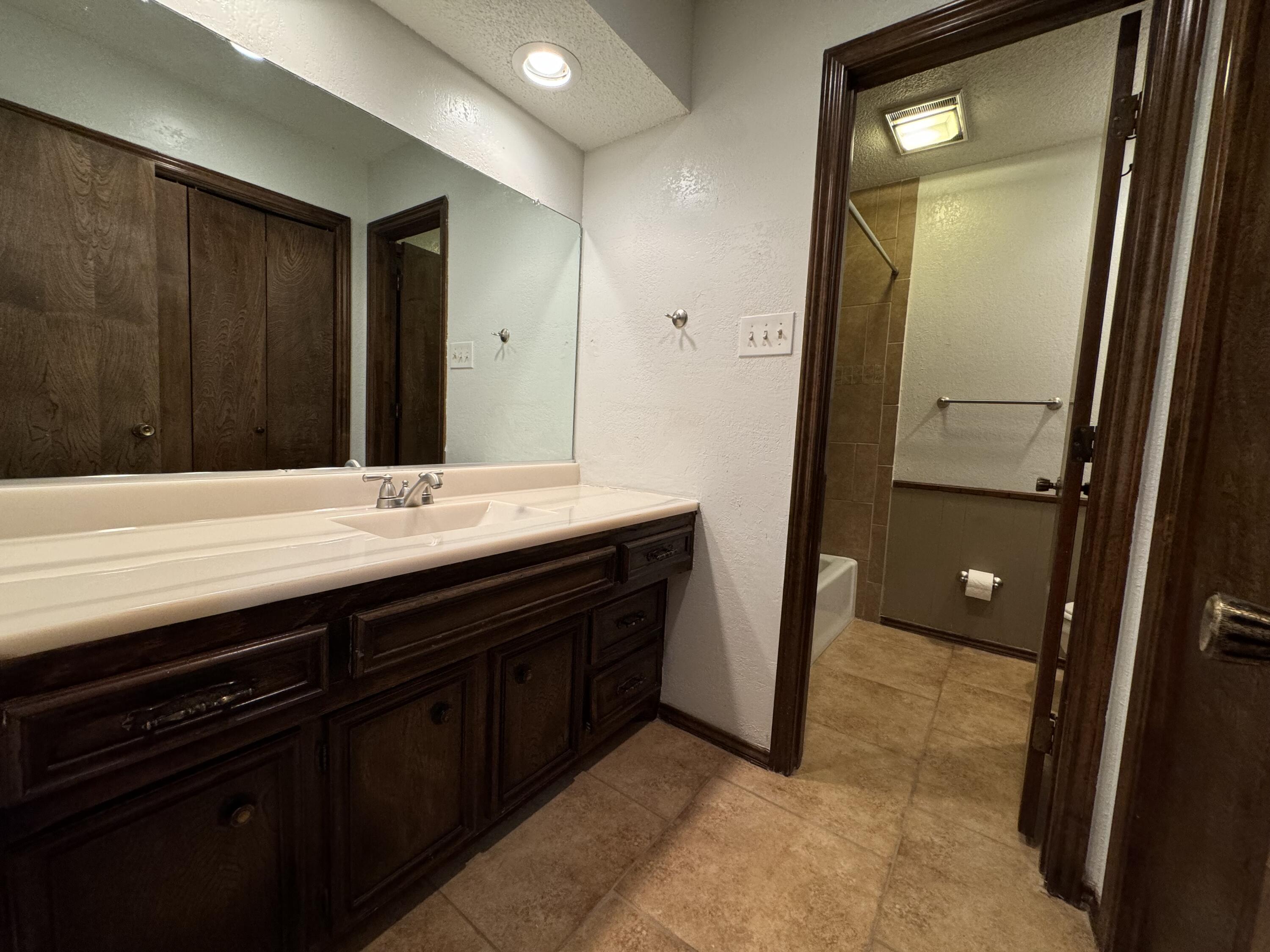 3103 75th Street, Unit B Lubbock, TX 79423 - Photo 16 of 22 a bathroom with a sink and a mirror