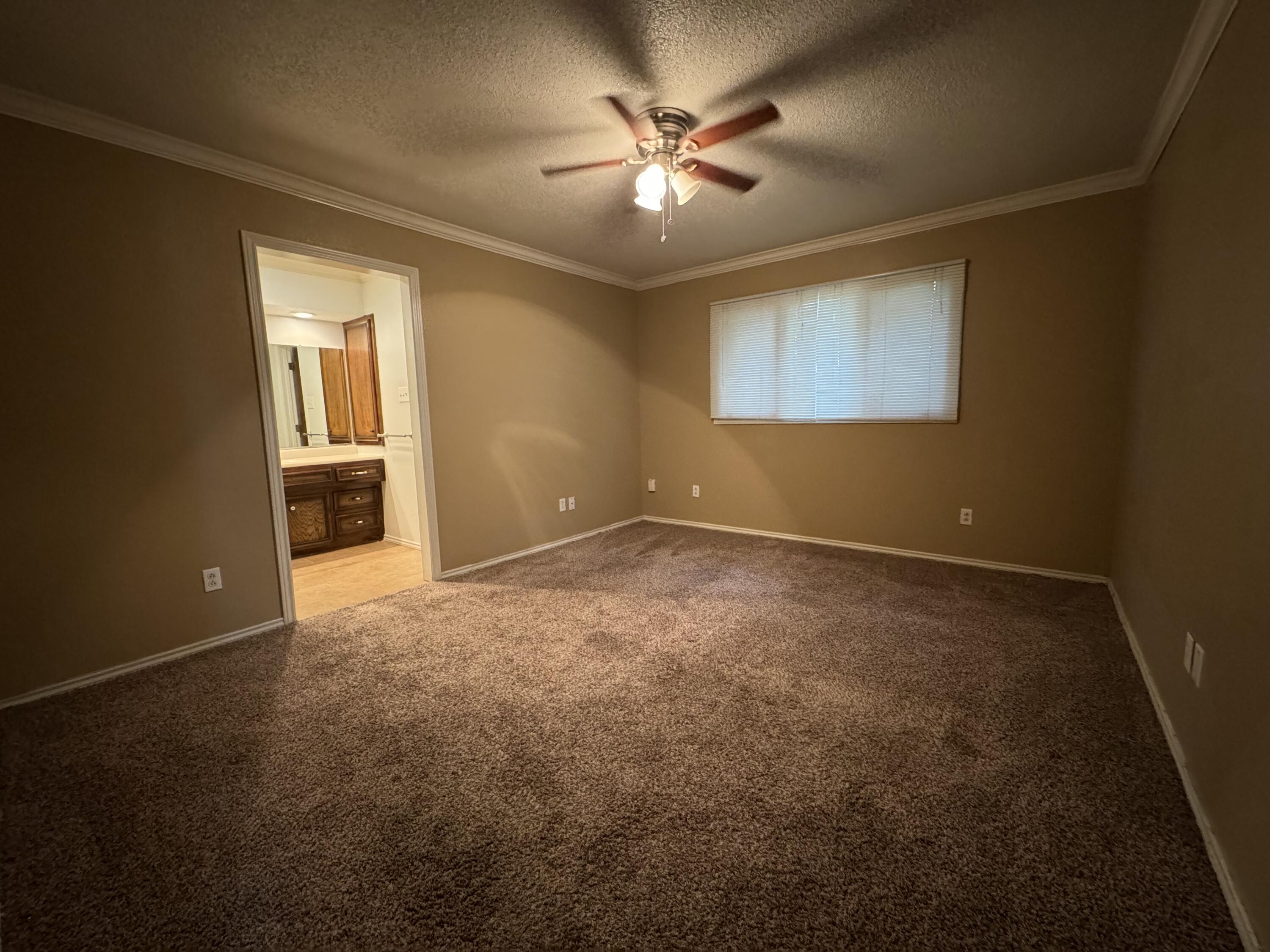 3103 75th Street, Unit B Lubbock, TX 79423 - Photo 19 of 22 an empty room with windows and fan