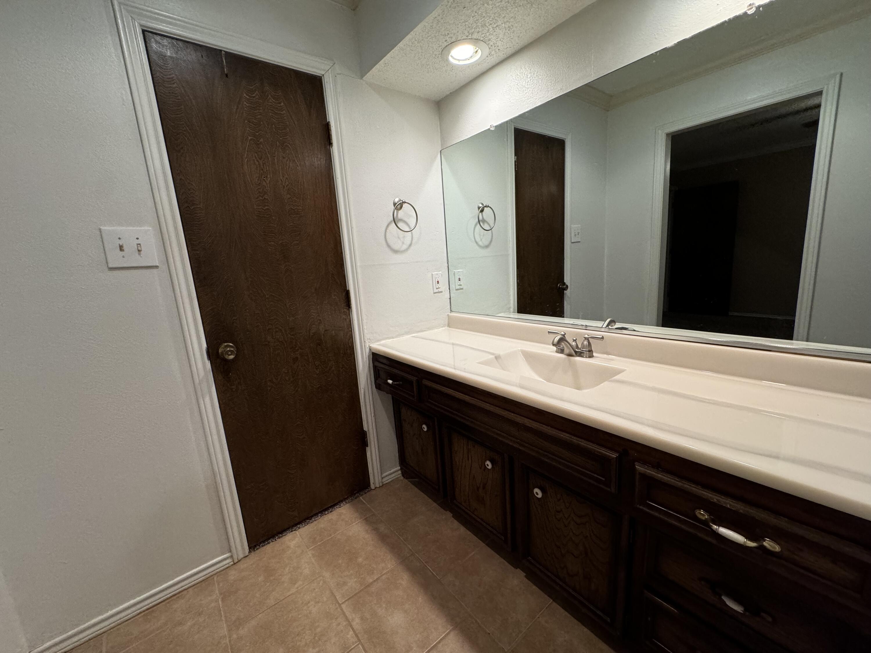 3103 75th Street, Unit B Lubbock, TX 79423 - Photo 20 of 22 a bathroom with a double vanity sink and mirror