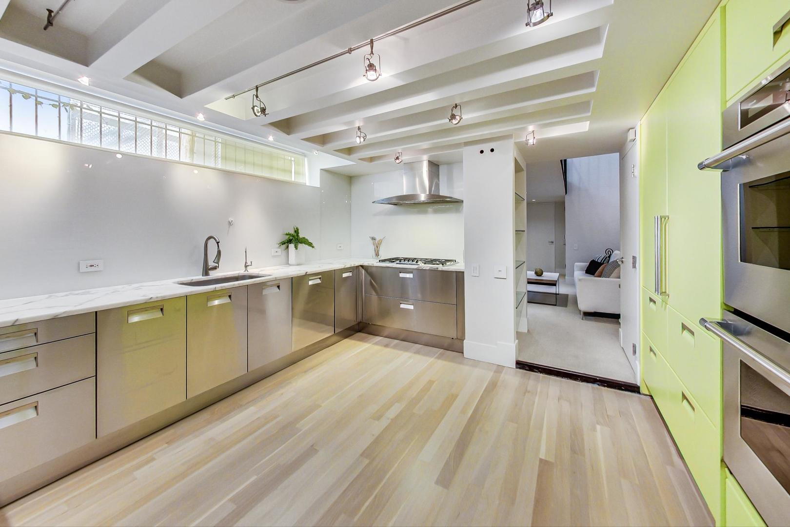 17 East Scott Street Chicago, IL 60610 - Photo 15 of 39 a large kitchen with a lot of counter space and wooden floor