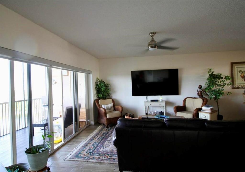 6425 Shoreline Drive, Unit 10503 St. Petersburg, FL 33708 - Photo 11 of 11 a living room with furniture wooden floor and a flat screen tv