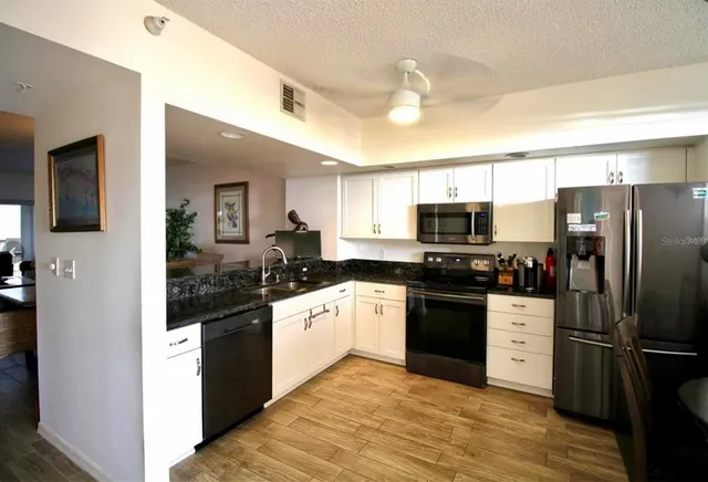 a kitchen with stainless steel appliances granite countertop a refrigerator and a stove top oven