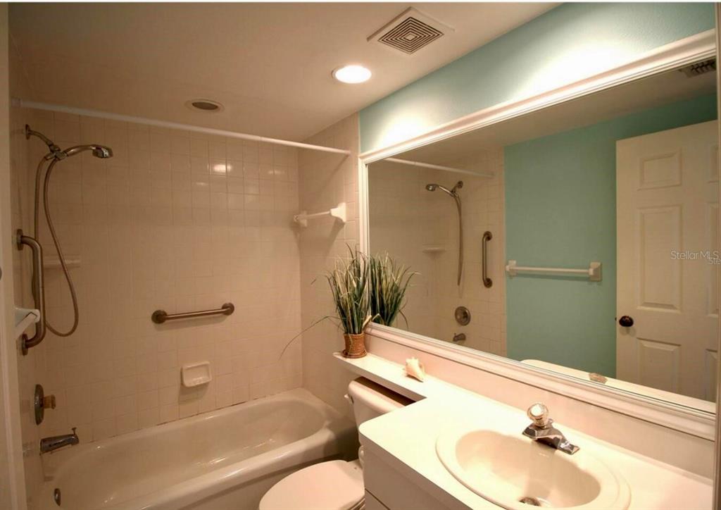 6425 Shoreline Drive, Unit 10503 St. Petersburg, FL 33708 - Photo 9 of 11 a bathroom with a sink shower and a mirror