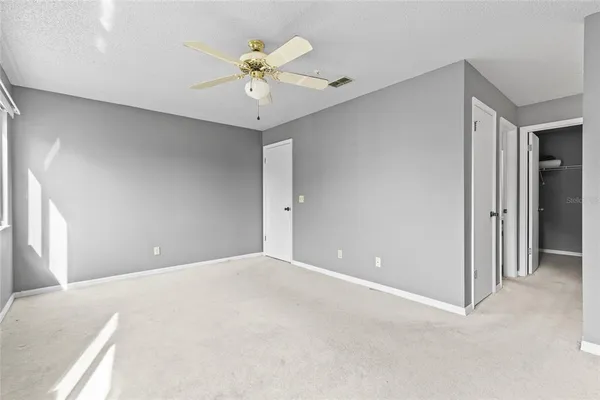 an empty room with fan and windows