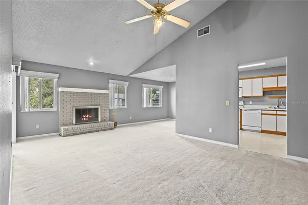 an empty room with windows and a fireplace