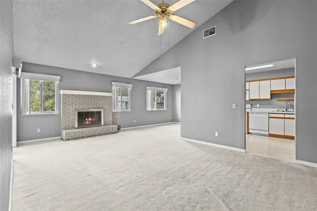 an empty room with windows and a fireplace