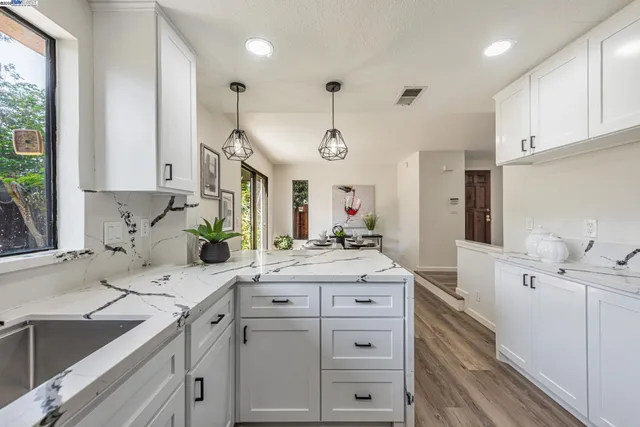 a kitchen with a sink and wooden floor
