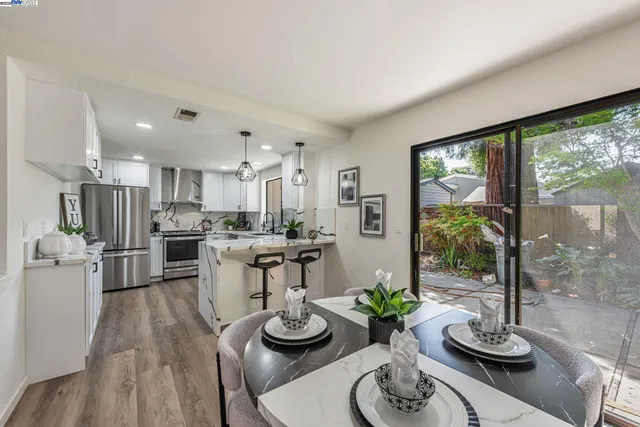 a living room with furniture a large window and wooden floor