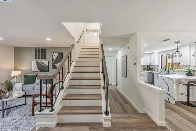a view of a hallway with wooden floor and staircase