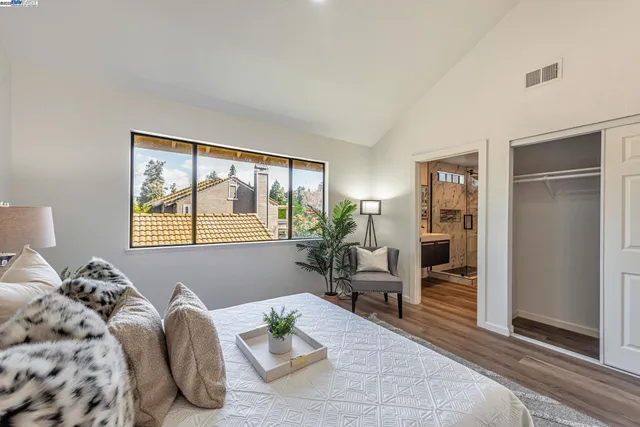 a bedroom with a bed and painting on the wall