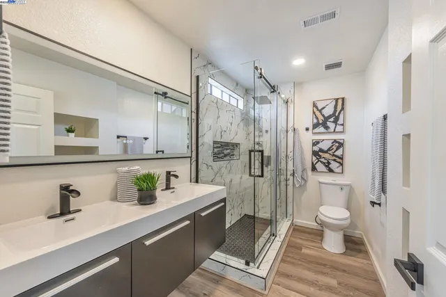 a bathroom with a sink a toilet and shower