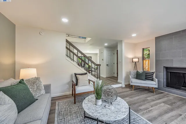 a kitchen with stainless steel appliances kitchen island granite countertop a stove a sink dishwasher a dining table and chairs with wooden floor