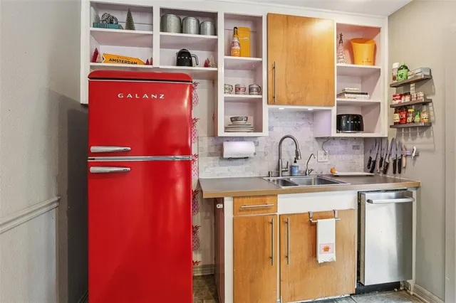 a kitchen with stainless steel appliances granite countertop a sink and a refrigerator