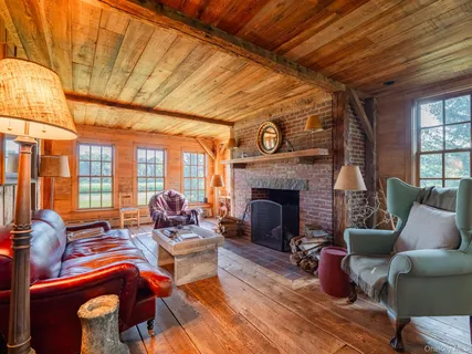 a living room with furniture a fireplace and wooden floor