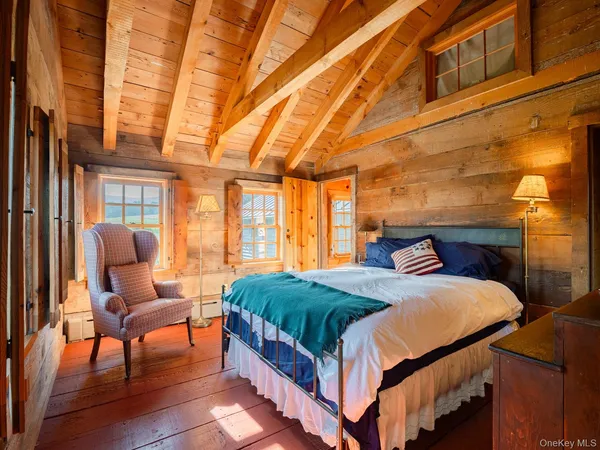 a bedroom with a bed chair and a large window