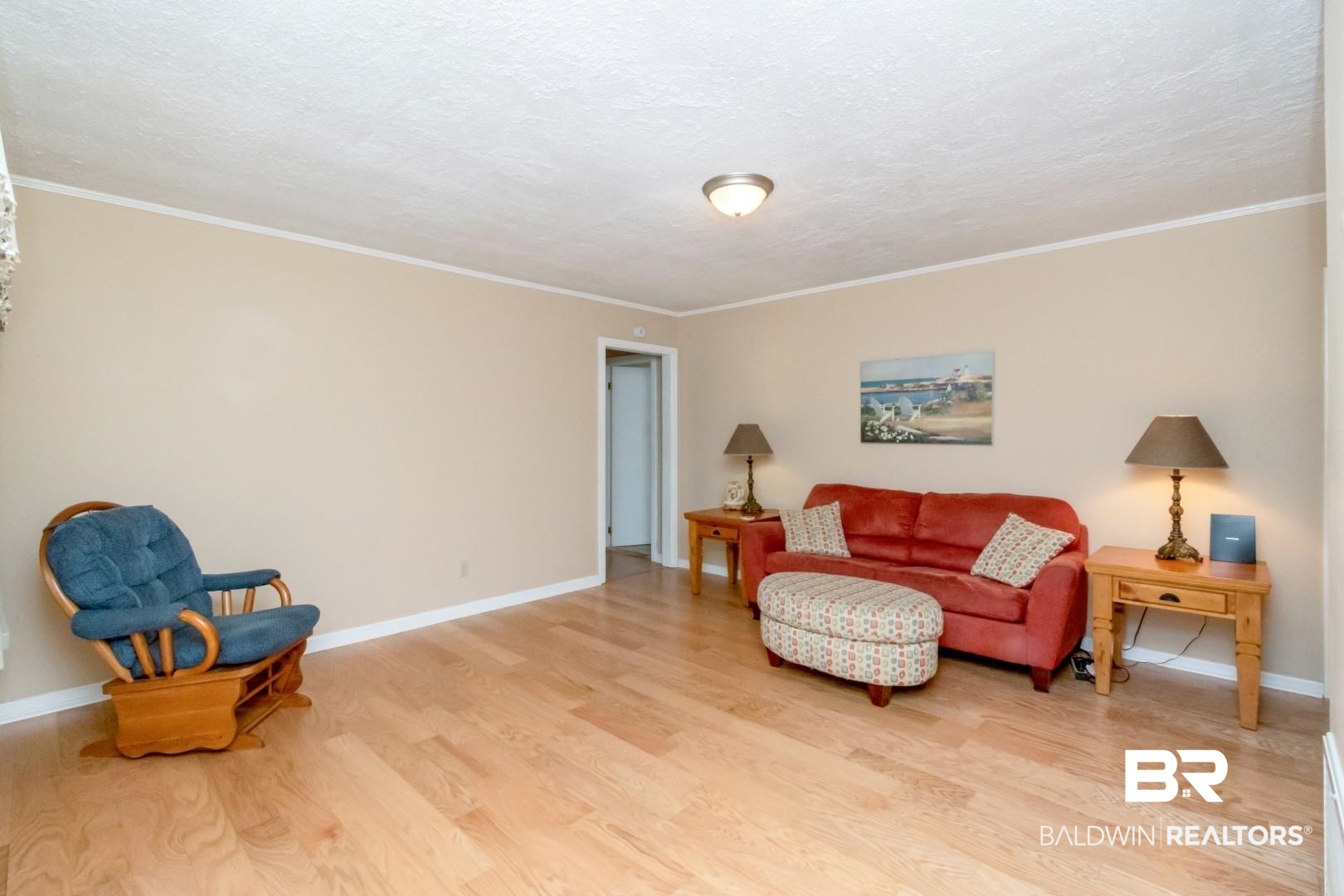 1321 Rainbow Drive West Mobile, AL 36693 - Photo 5 of 48 Living area featuring crown molding, a textured ceiling, and light wood-type flooring