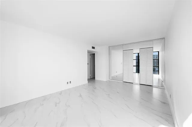 an empty room with wooden floor and natural light