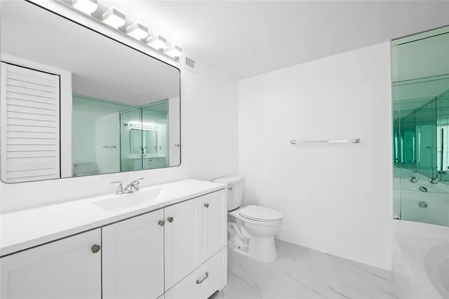 a bathroom with a sink a toilet and a mirror