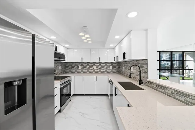 a kitchen with granite countertop a sink stainless steel appliances and cabinets