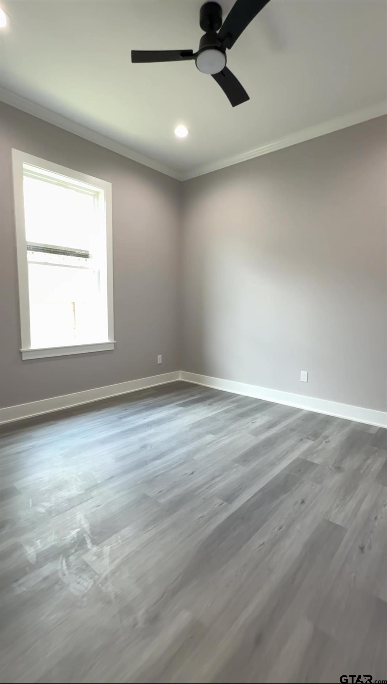 9065 Long Branch Tyler, TX 75703 - Photo 21 of 25 an empty room with a window and a ceiling fan