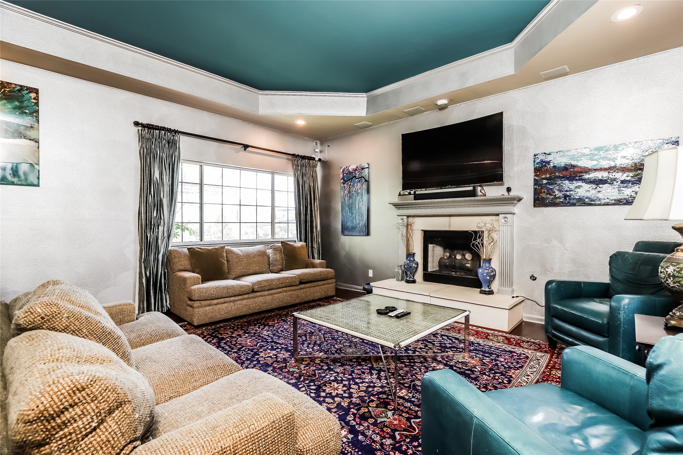 1702 Newning Avenue, Unit A Austin, TX 78704 - Photo 3 of 20 Living area featuring a tray ceiling with a contrasting painted inset, a fireplace with a mantel, and dark wood-finish flooring