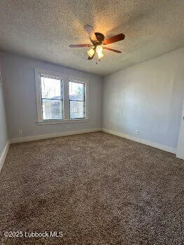 an empty room with windows and chandelier fan