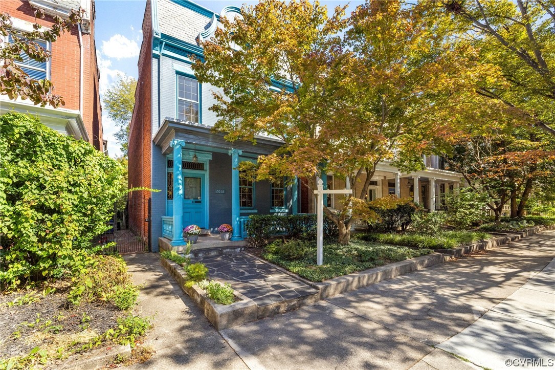 a view of a brick house with a large windows and large trees