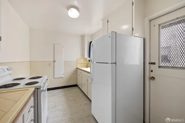a kitchen with a refrigerator and a stove top oven