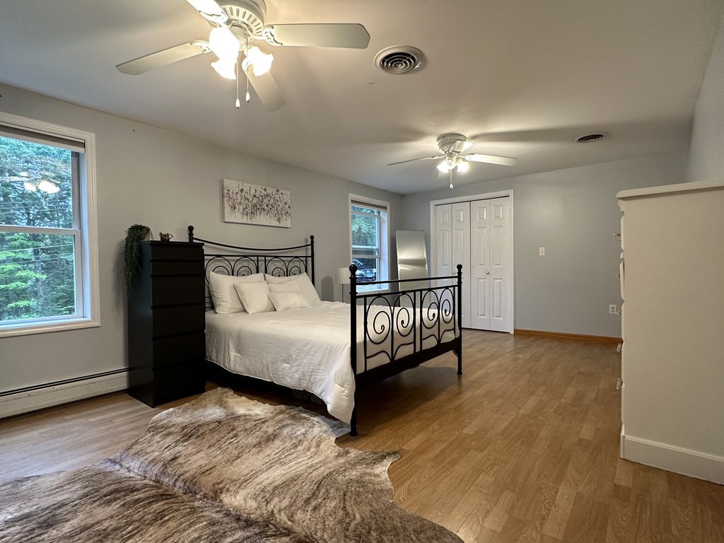 210 Pine Hill Road Russell, MA 01071 - Photo 24 of 29 a spacious bedroom with a bed and a chandelier