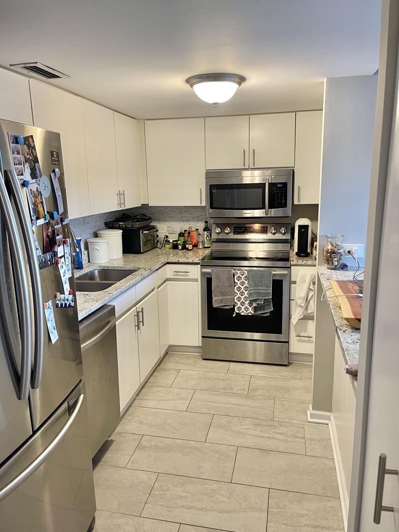 440 North Wabash Avenue, Unit 1903 Chicago, IL 60611 - Photo 11 of 34 a kitchen with stainless steel appliances granite countertop a stove a sink and a refrigerator