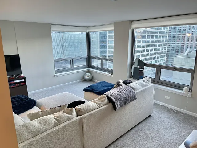 a living room with furniture and a floor to ceiling window