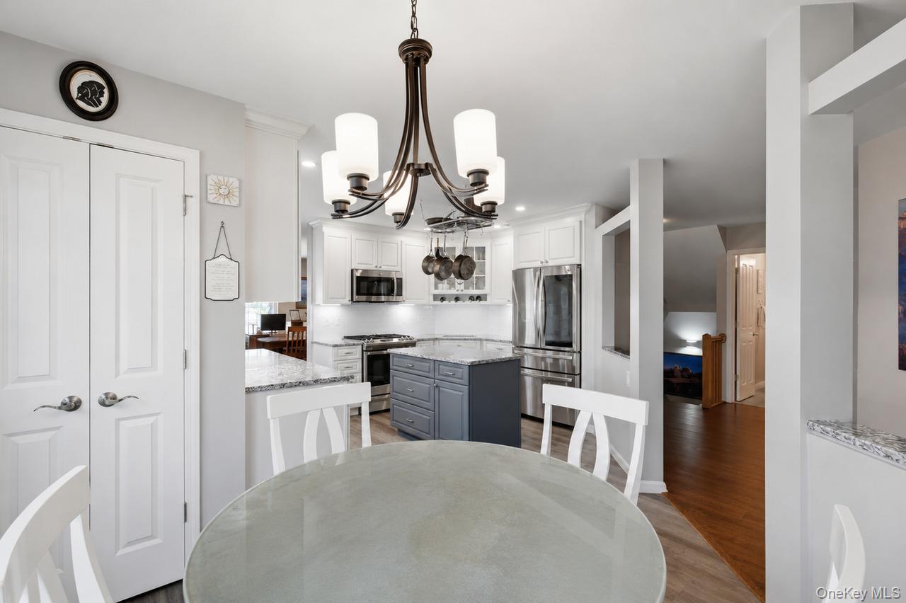 64 Roma Orchard Road Peekskill, NY 10566 - Photo 10 of 40 Kitchen featuring a central island with a contrasting base, white shaker-style cabinetry, stainless steel appliances, and light-toned countertops