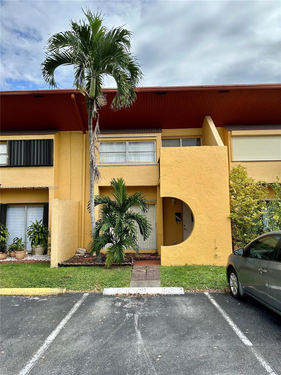 13705 Southwest 84th Street, Unit F Miami, FL 33143 - Photo 2 of 12 a front view of a house with garden