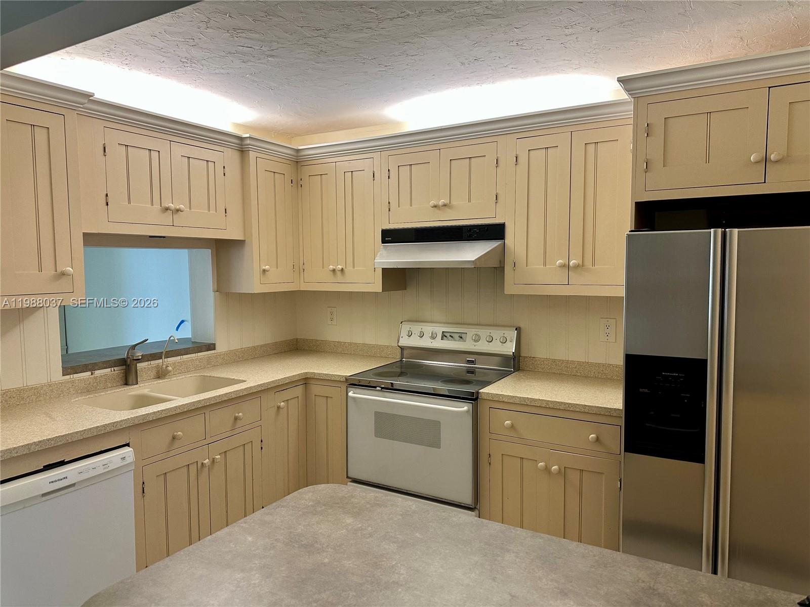 13705 Southwest 84th Street, Unit F Miami, FL 33143 - Photo 7 of 12 a kitchen with white cabinets and stainless steel appliances