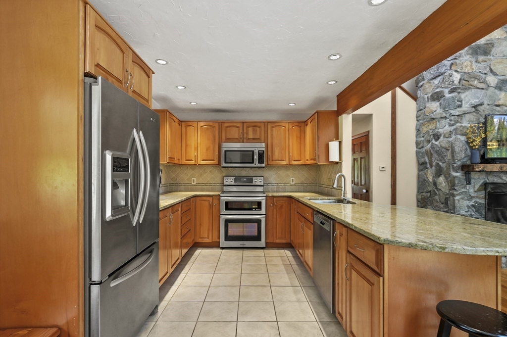 19 Sprague Road Clinton, MA 01510 - Photo 12 of 40 a kitchen with stainless steel appliances granite countertop a refrigerator a stove top oven a sink and dishwasher