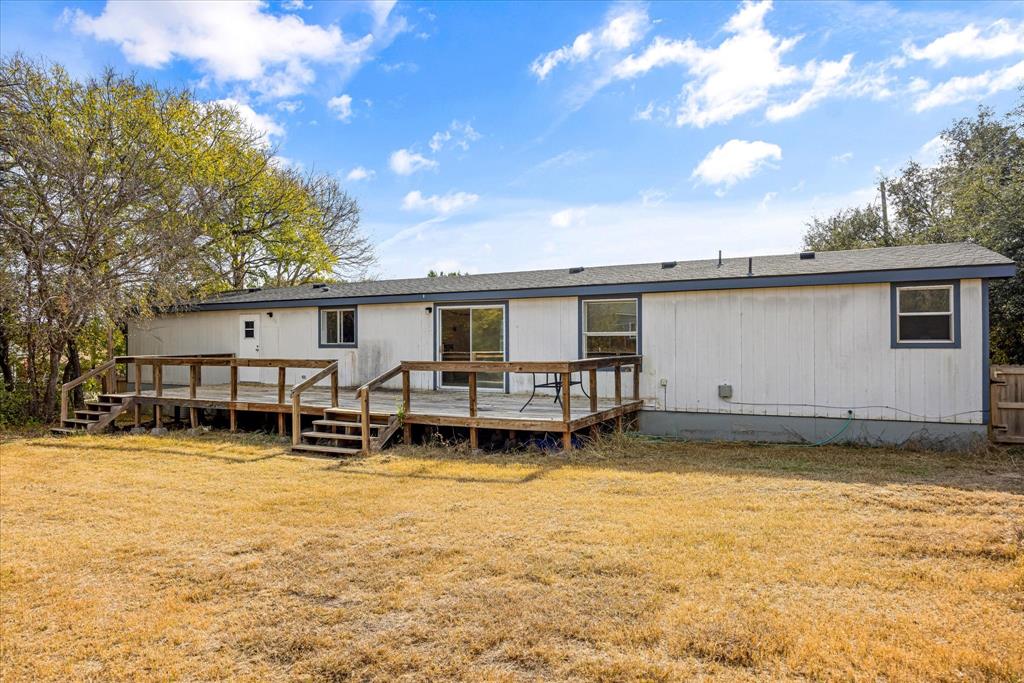 2903 Centaurus Way Granbury, TX 76048 - Photo 28 of 31 Rear view of property with a lawn, a wooden deck, and a shingled roof