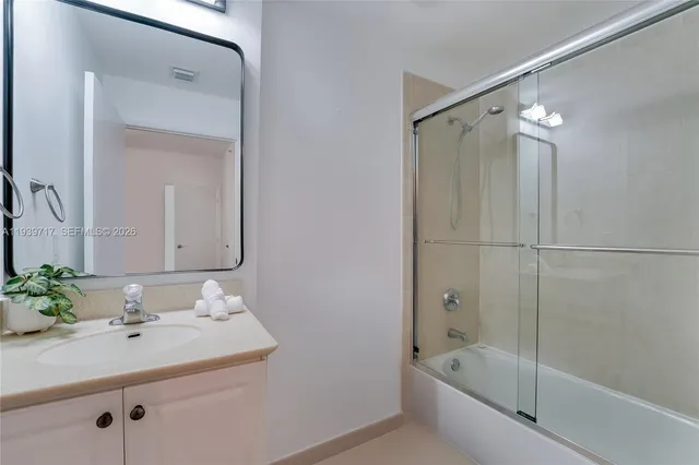 a bathroom with a bath tub sink vanity and mirror