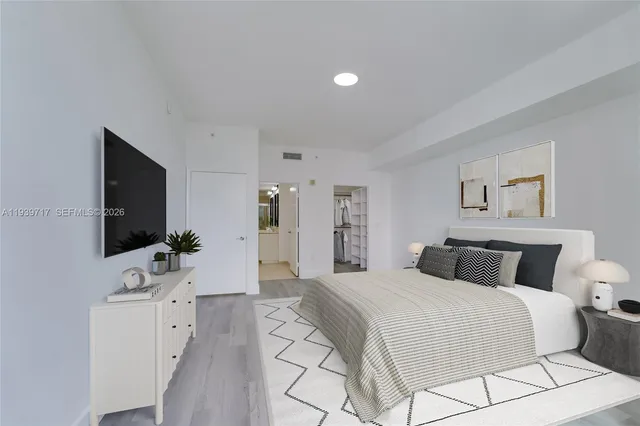 a bedroom with a large bed and a flat screen tv