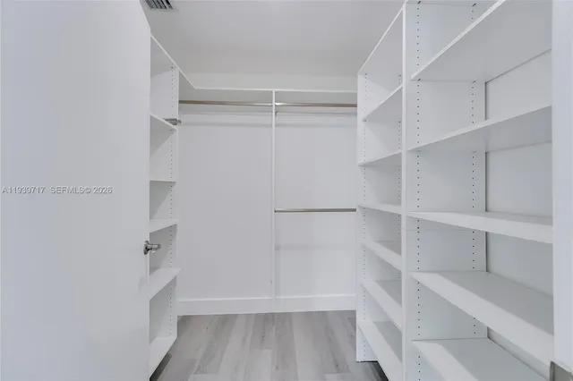 a view of walk in closet with empty racks