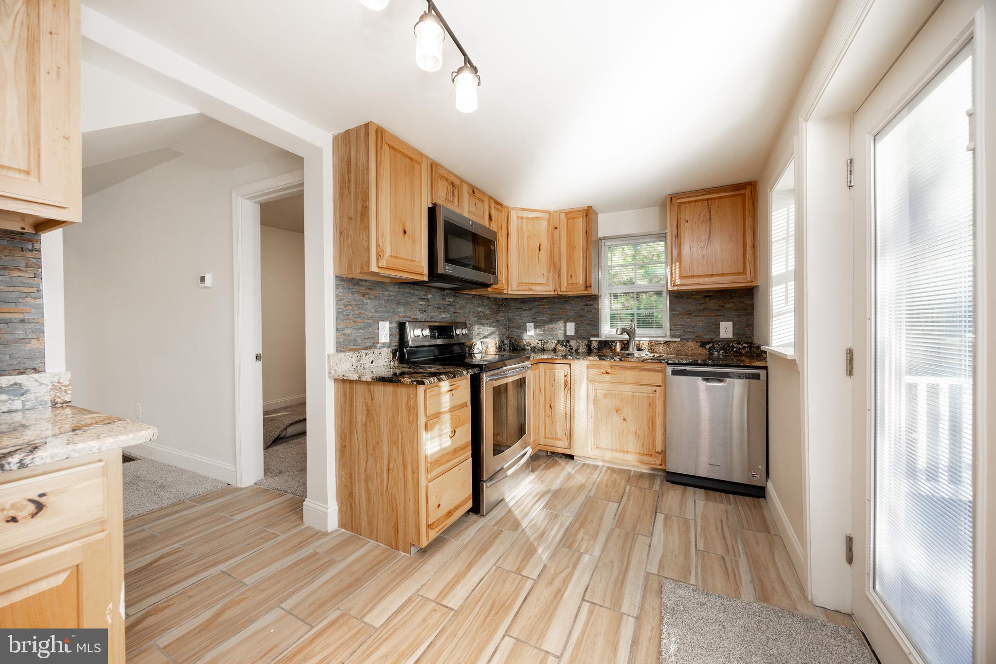 103 Valley View Road Phoenixville, PA 19460 - Photo 11 of 38 a kitchen with stainless steel appliances granite countertop a refrigerator a sink dishwasher a stove with wooden cabinets and floor