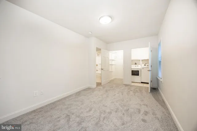 an empty room with white wall and windows