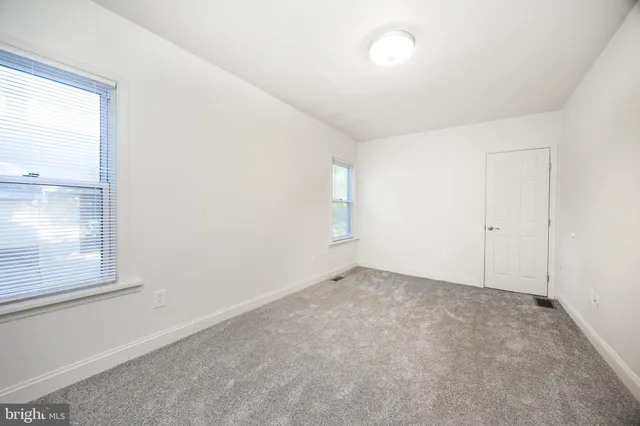 an empty room with windows and closet