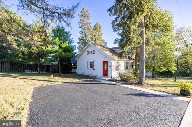 a view of a house with a yard and large tree