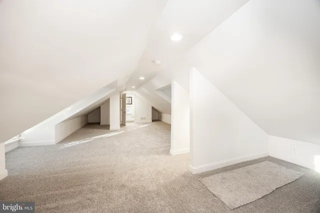 a view of an empty room and kitchen